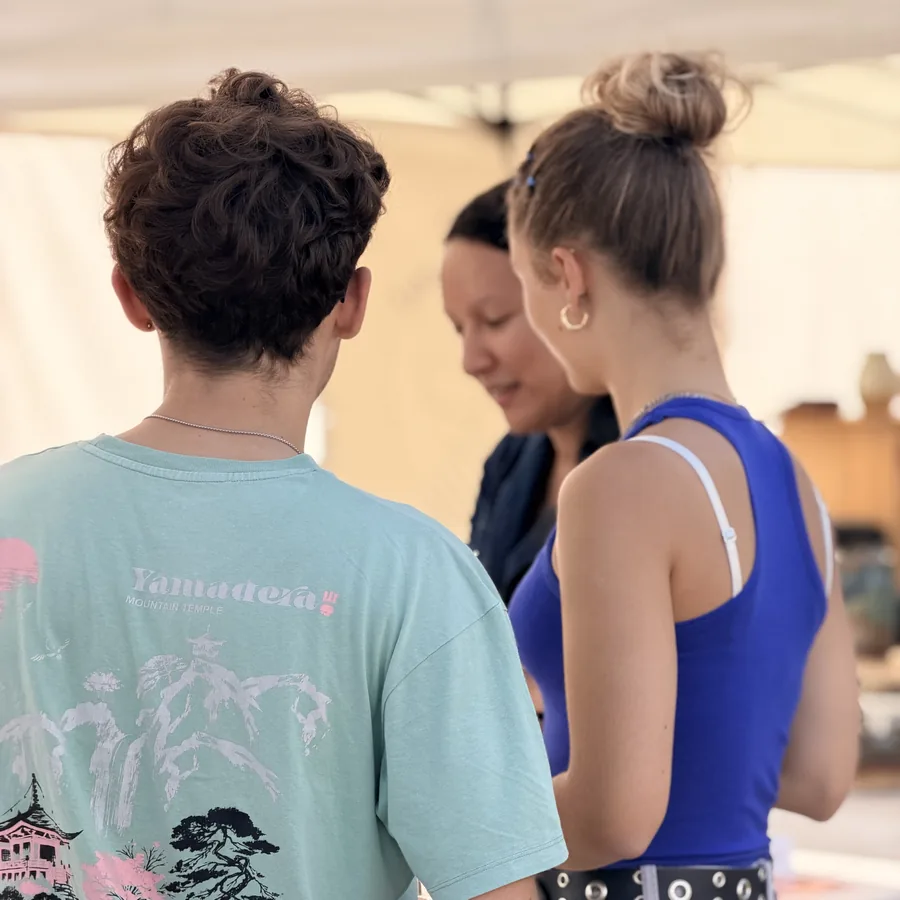Deux participantes échangent avec Aline autour des parfums lors d'un atelier olfactif