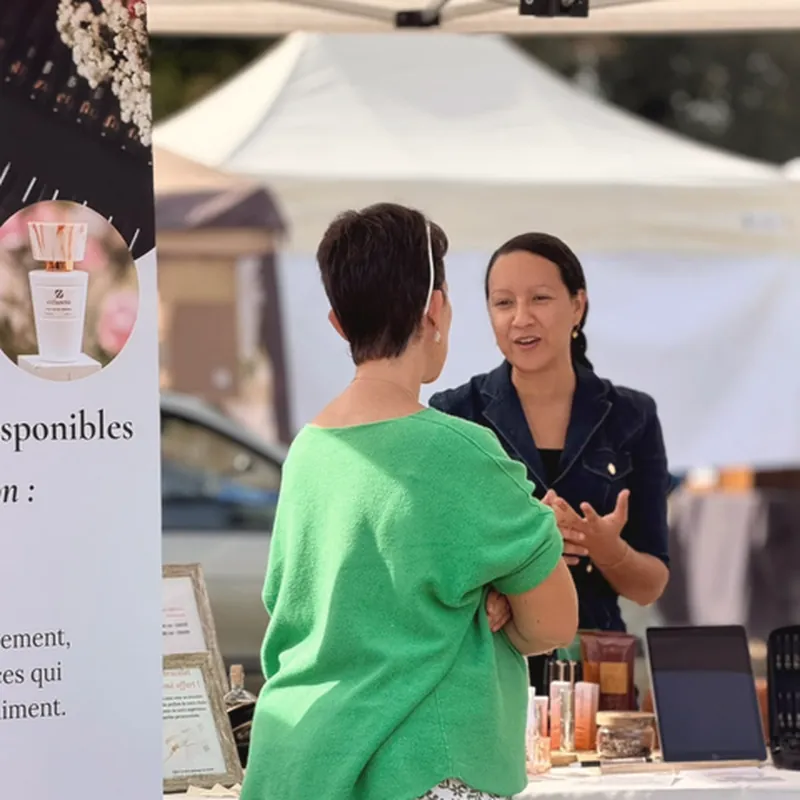 Aline conseille une cliente sur le stand de la parfumerie ambulante