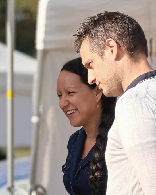 Aline et son mari, souriants, sur le stand de la parfumerie ambulante